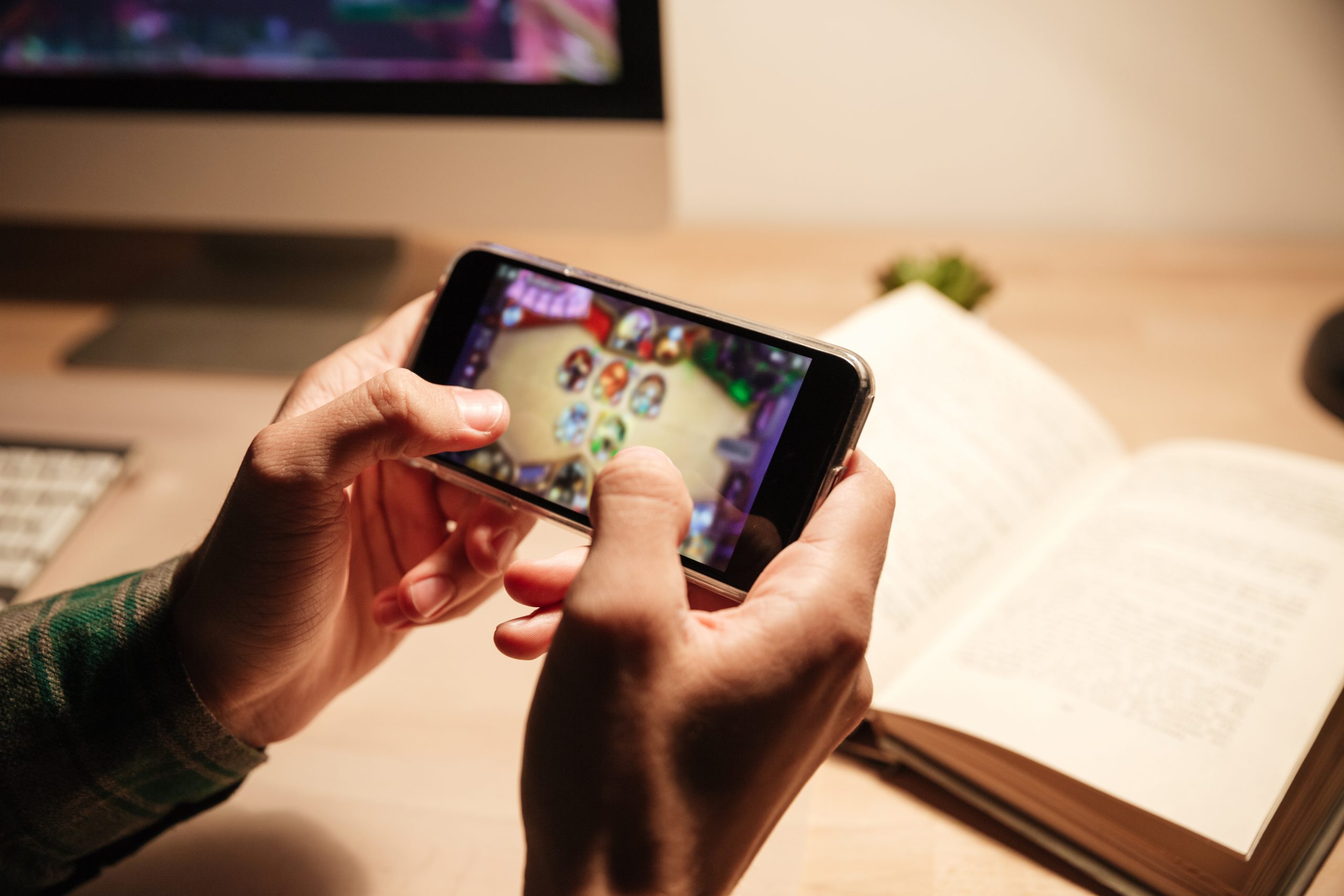 Closeup Of Man Hands Playing Videogames On Cell Phone In